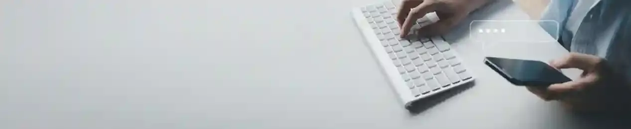 Person typing on keyboard and holding smartphone to submit RTI online for passport delay through FileMyRTI
